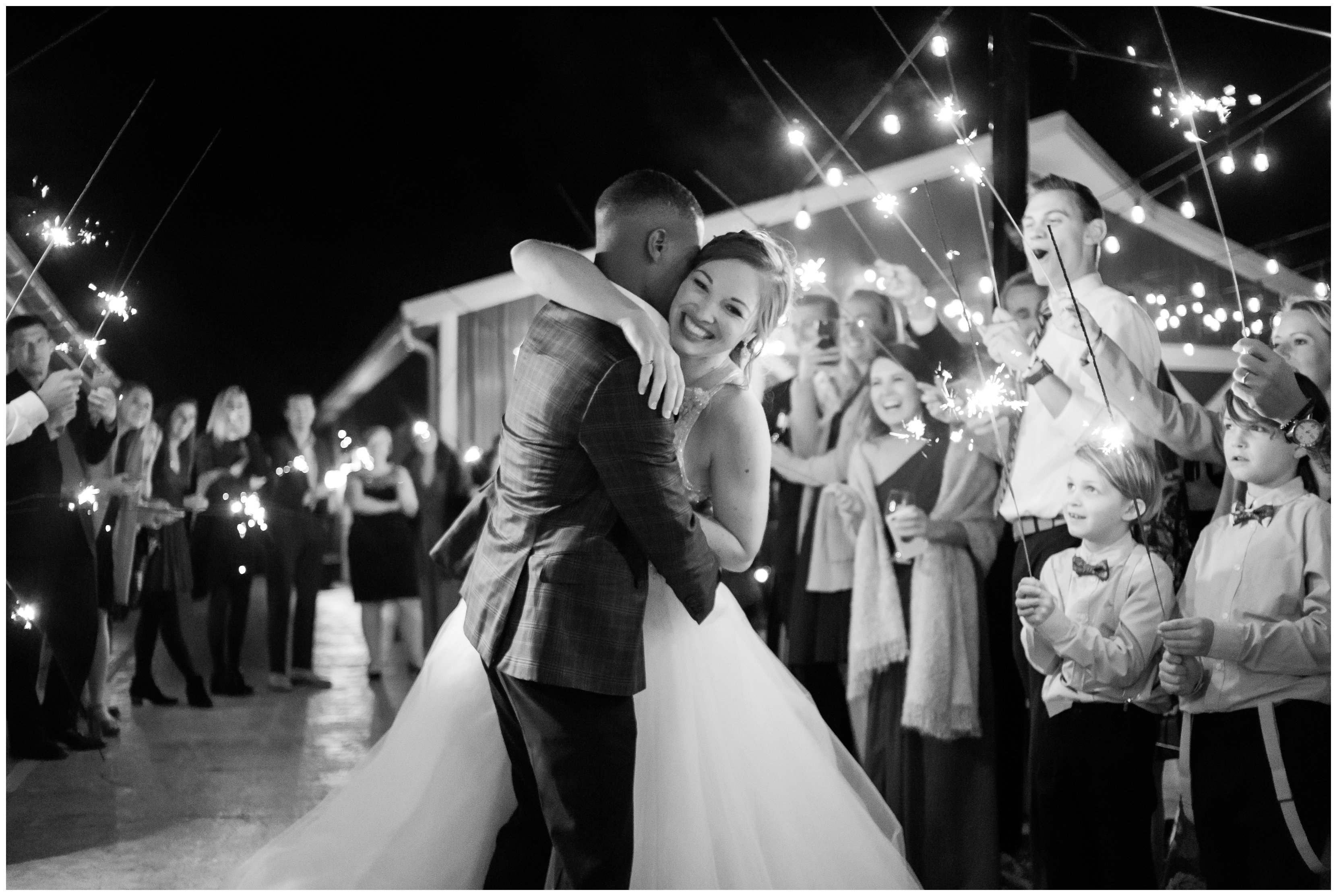 groom kisses bride under sparklers at grand exit at new kent winery
