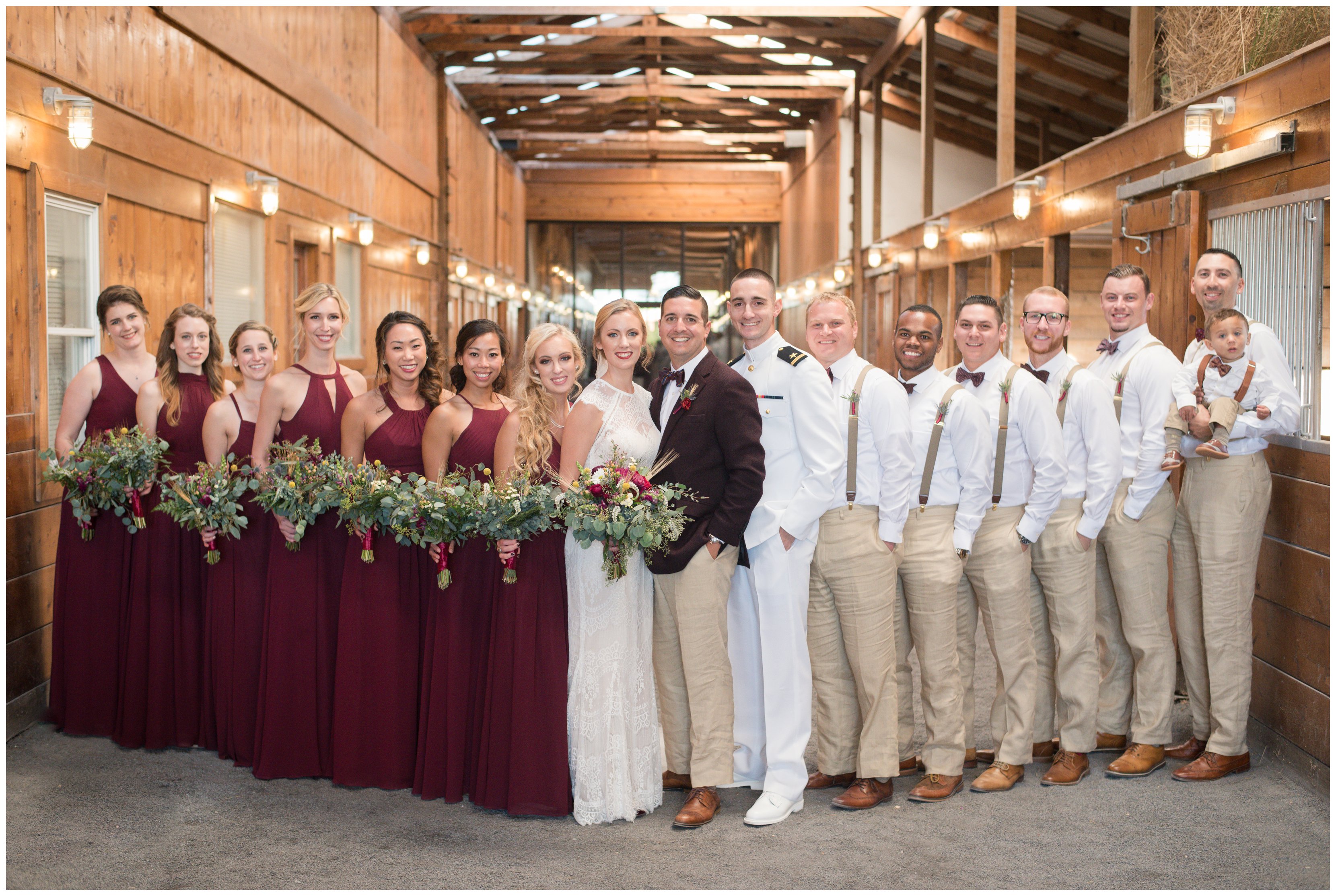 large wedding party stands in stable at hermitage hill farm wedding