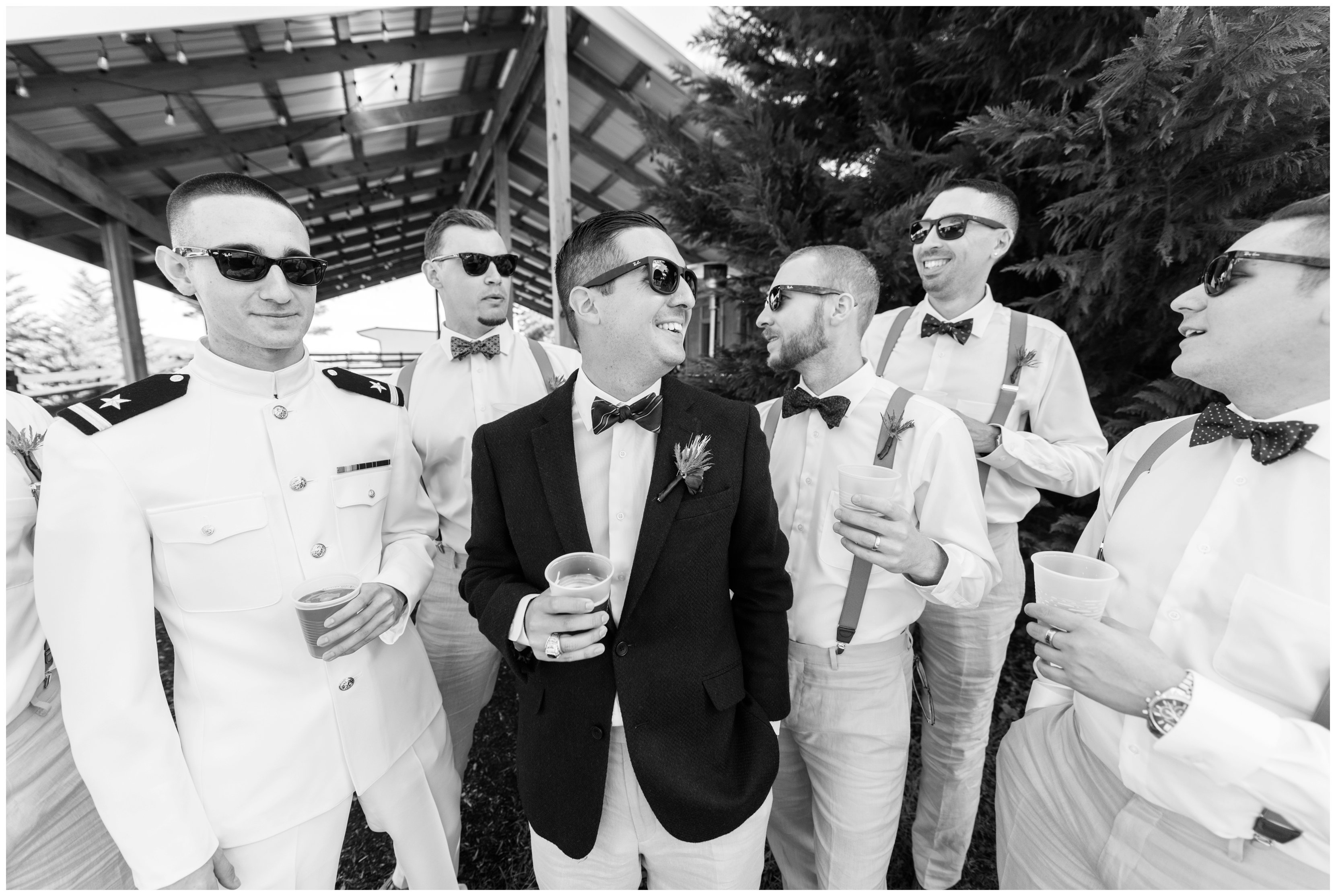 groomsmen candidly drink together at hermitage hill farm wedding