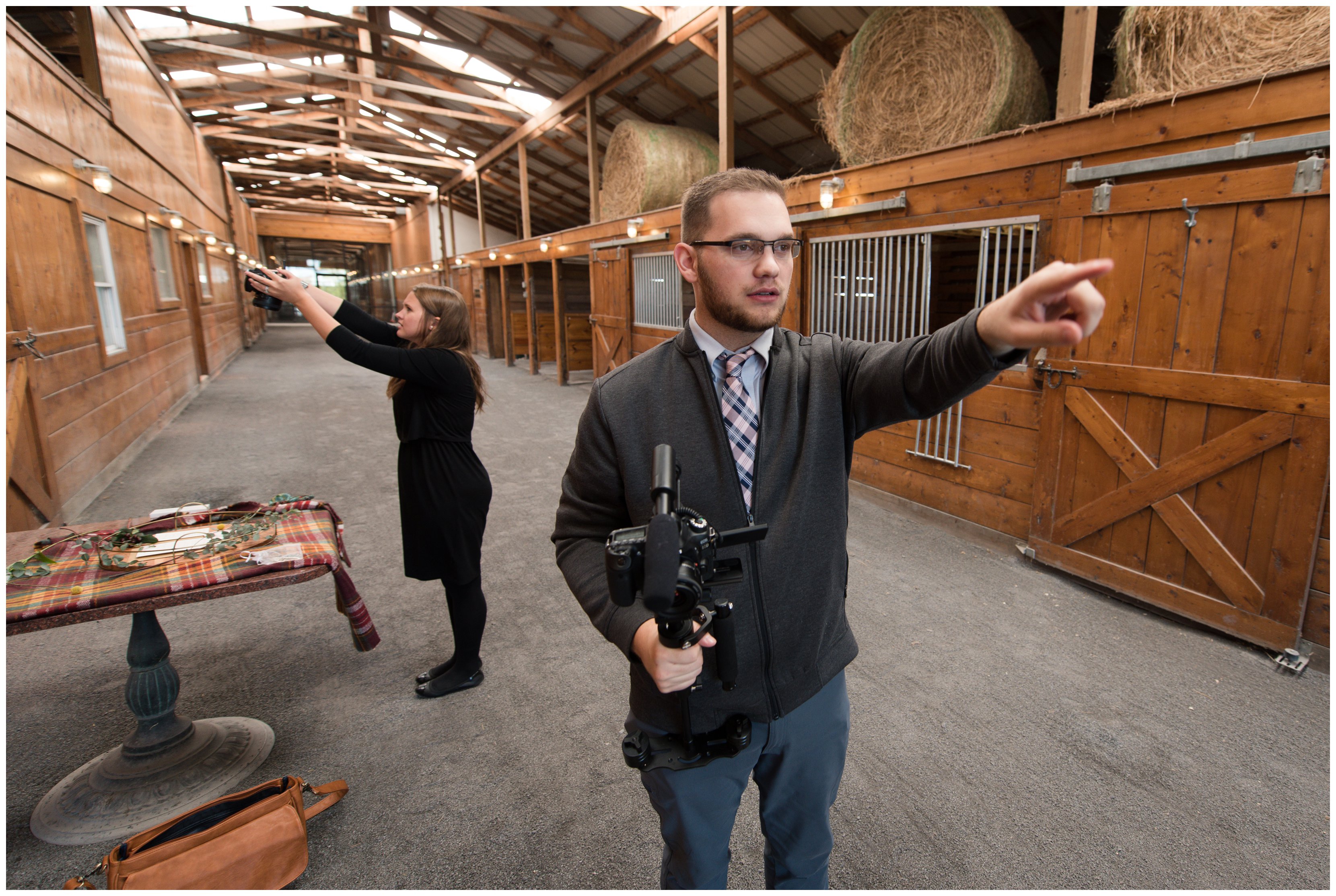 virginia videographer points while photographer photographs details in barn