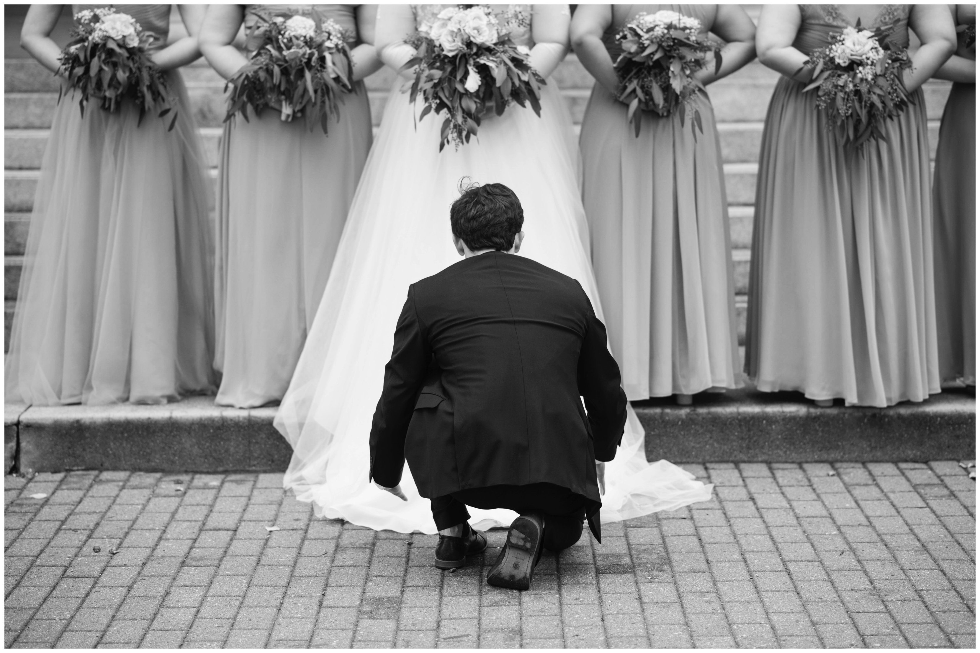 photographer fixes dress of bride at hampton virginia wedding