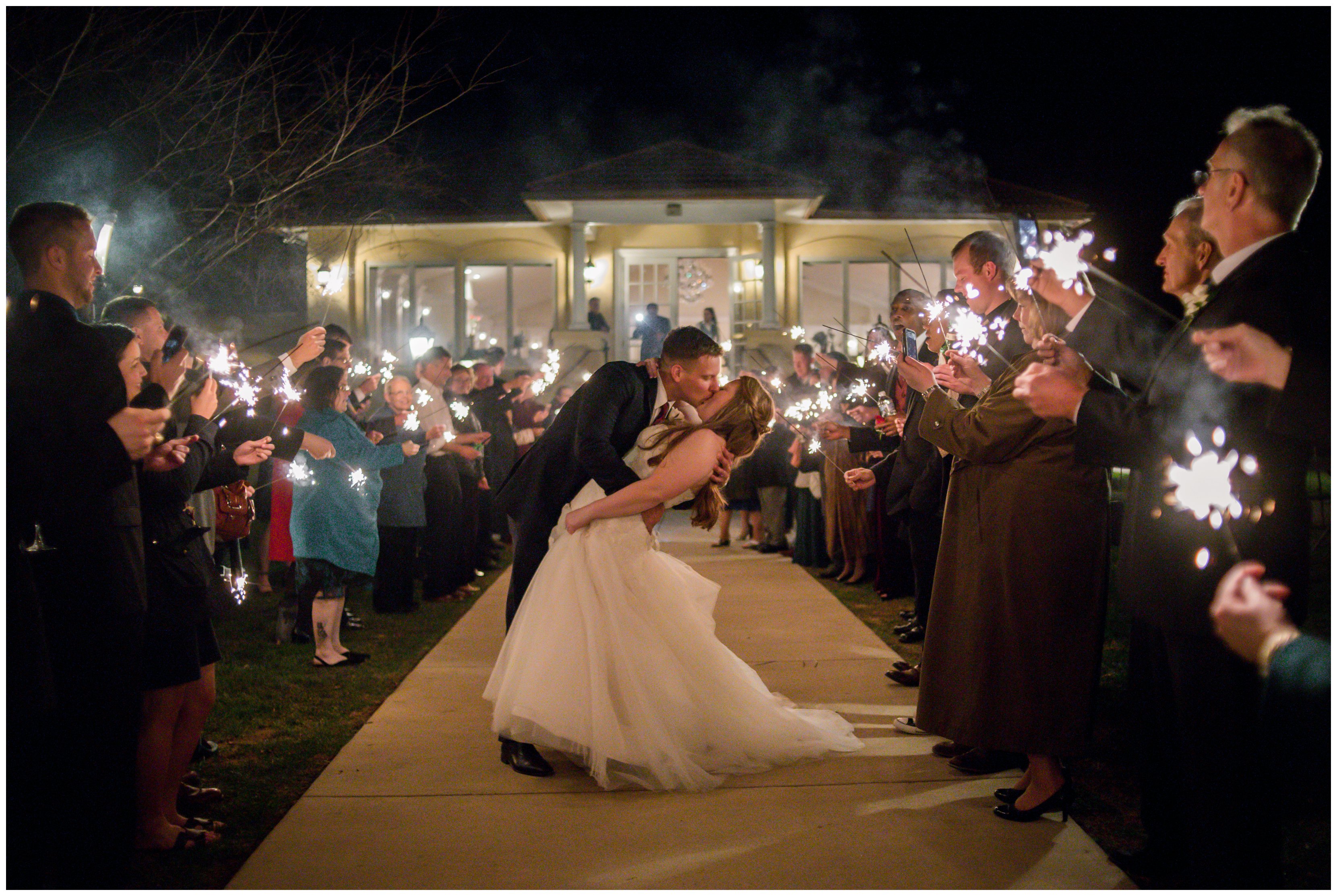 bride and groom kiss under sparklers at exit from reception at breaux vineyard